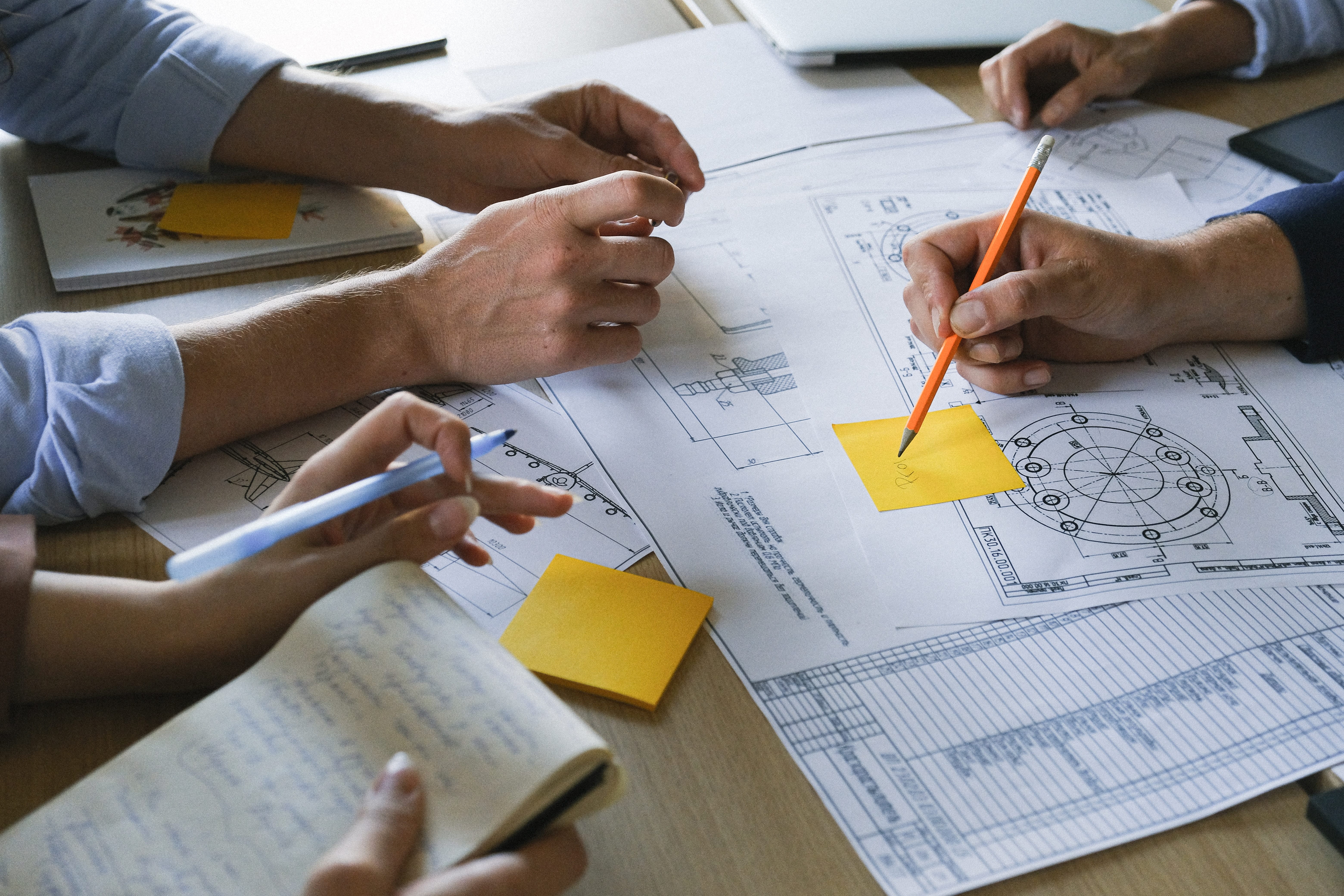 group planning around a construction blueprint